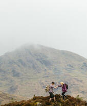 Couple hiking in the mountains on a cloudy day