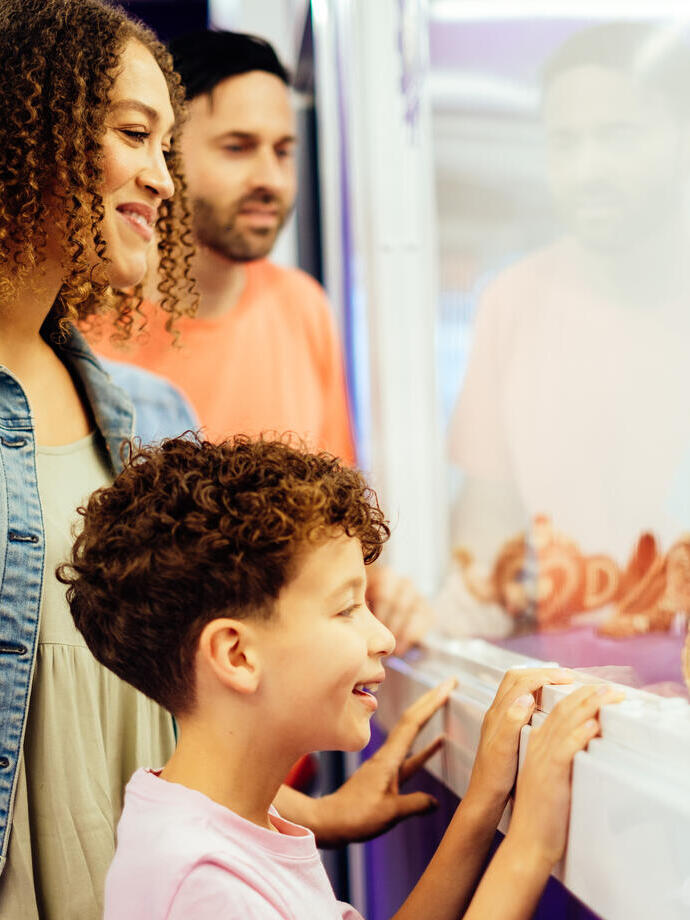 Un niño pequeño, con sus padres, mirando una exposición de chocolate