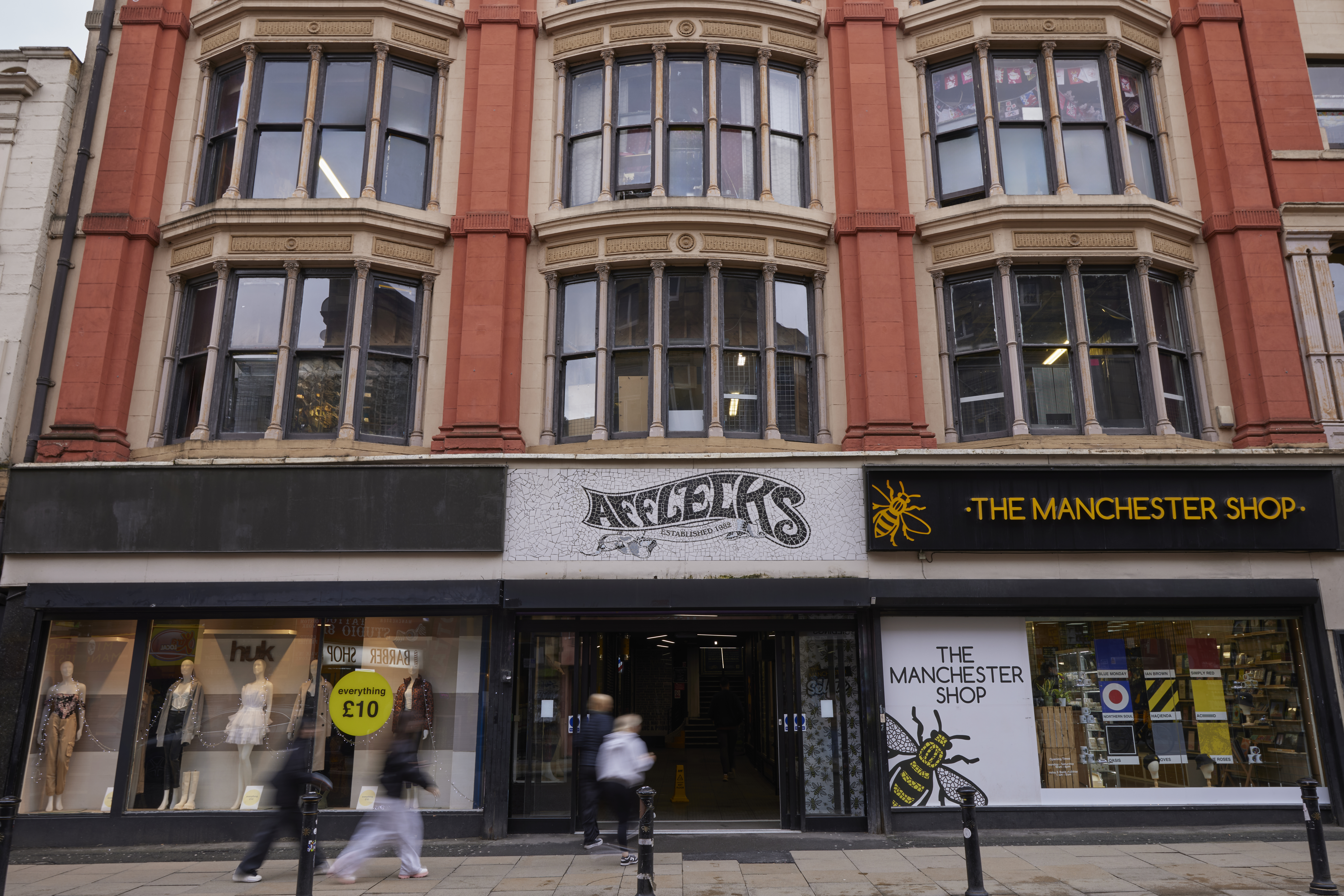 The exterior of Afflecks and The Manchester Shop with people walking past on the pavement in Manchester city centre.