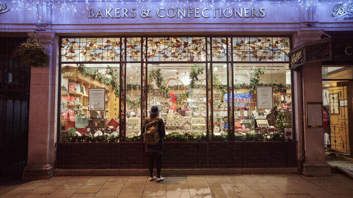 Woman looking into a shop window in the evening at Christmas