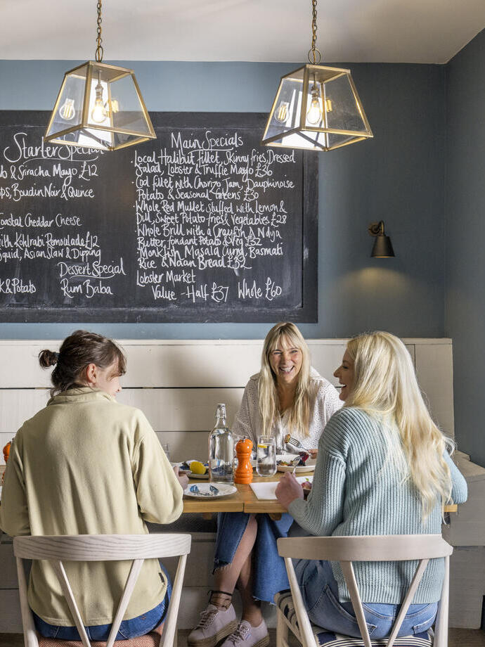Three women eat lunch inside a restaurant