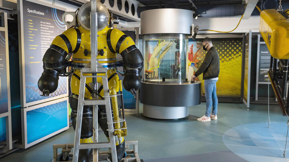 A man looking at an exhibit in a maritime museum.