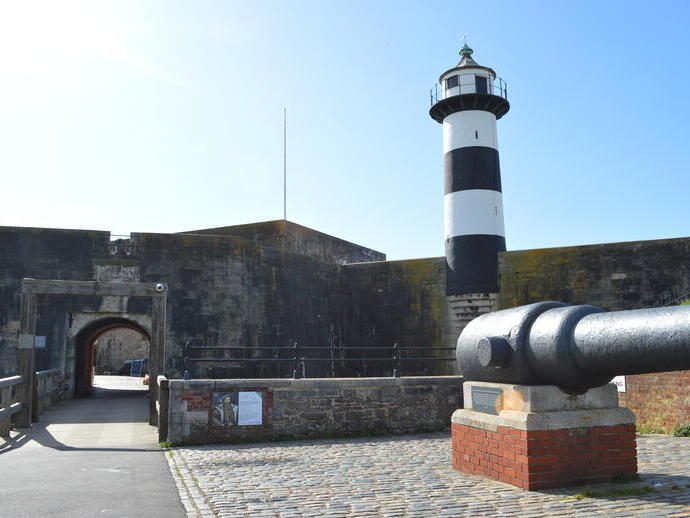 A lighthouse and cannon in the grounds of an old castle