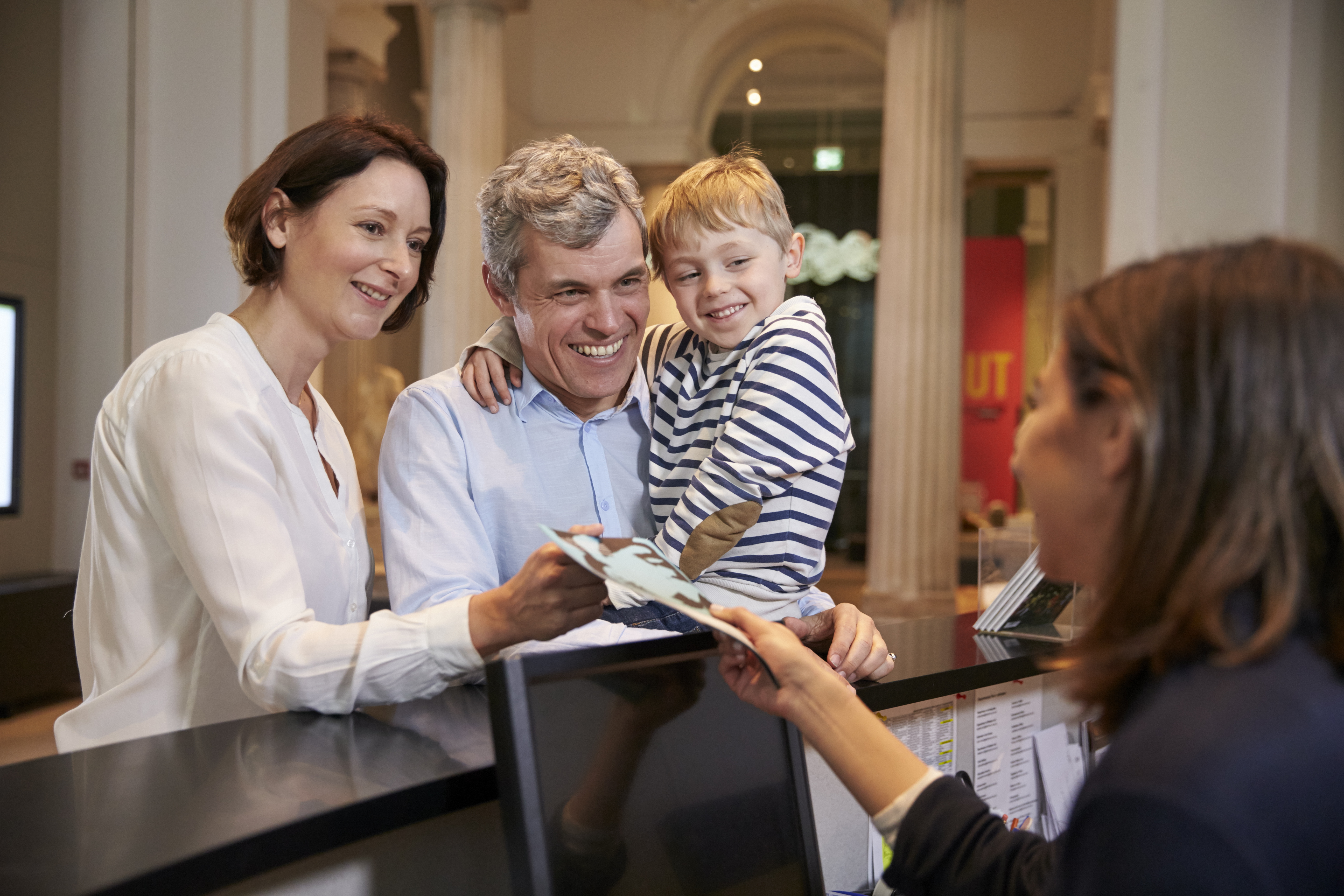 Family buying entry tickets in a museum