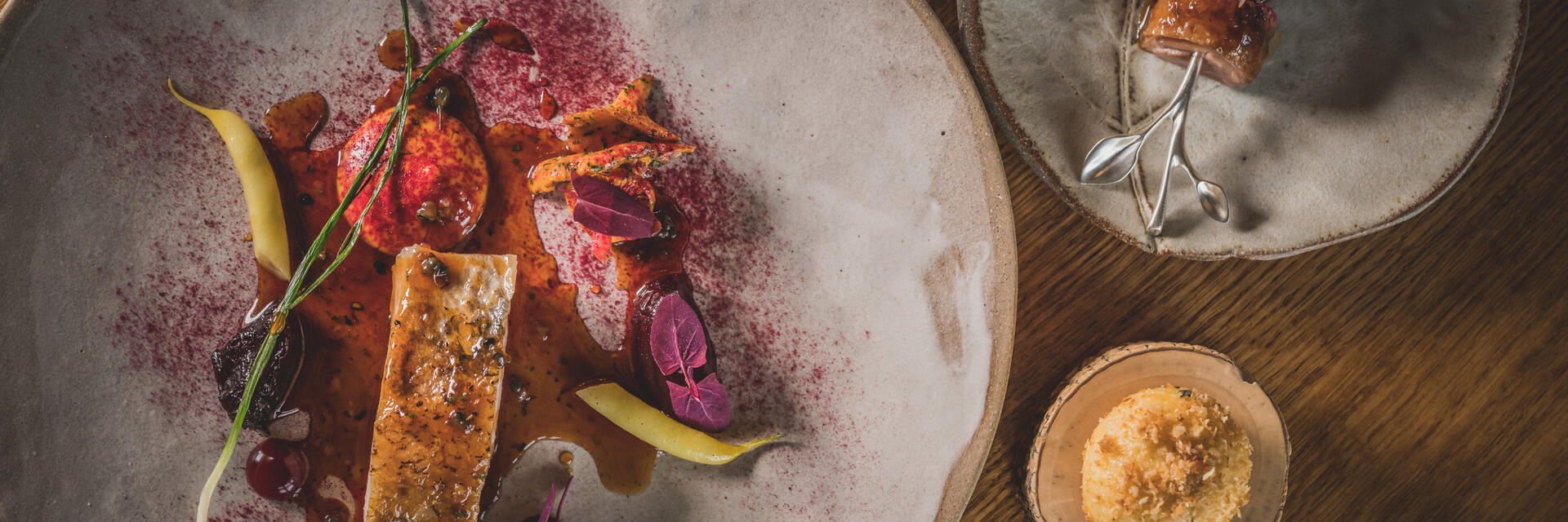 Three different sized plates of colourful food served on rustic grey crockery