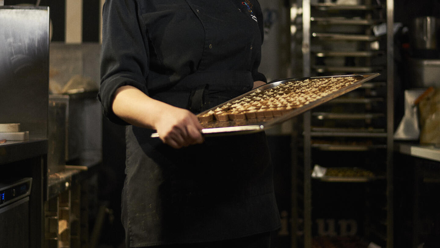 Woman presenting tray with chocolate truffles