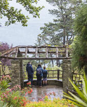 Visitors taking in the view of the sea from the garden at Coleton Fishacre