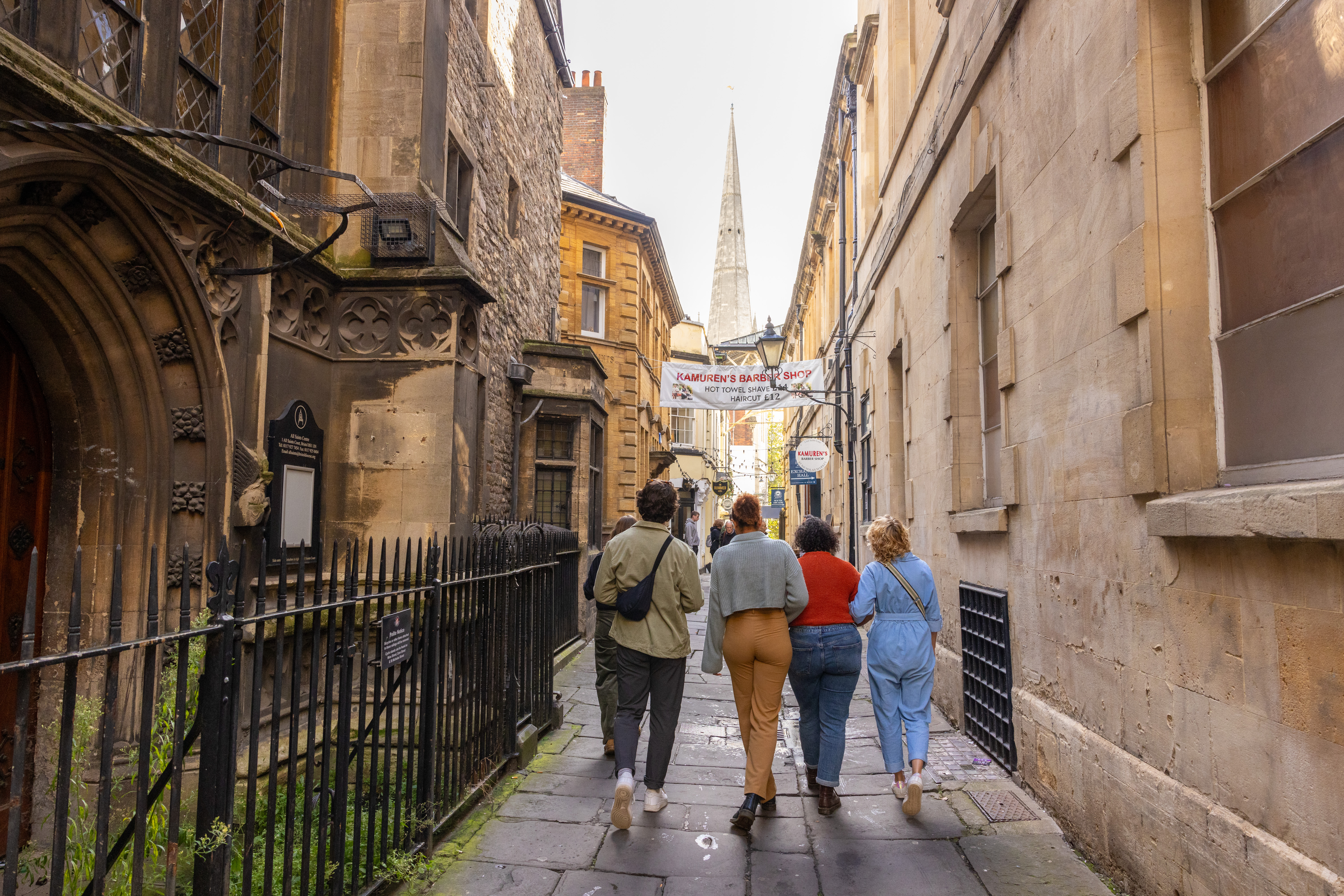 Group of friends walking on a cobbled street.