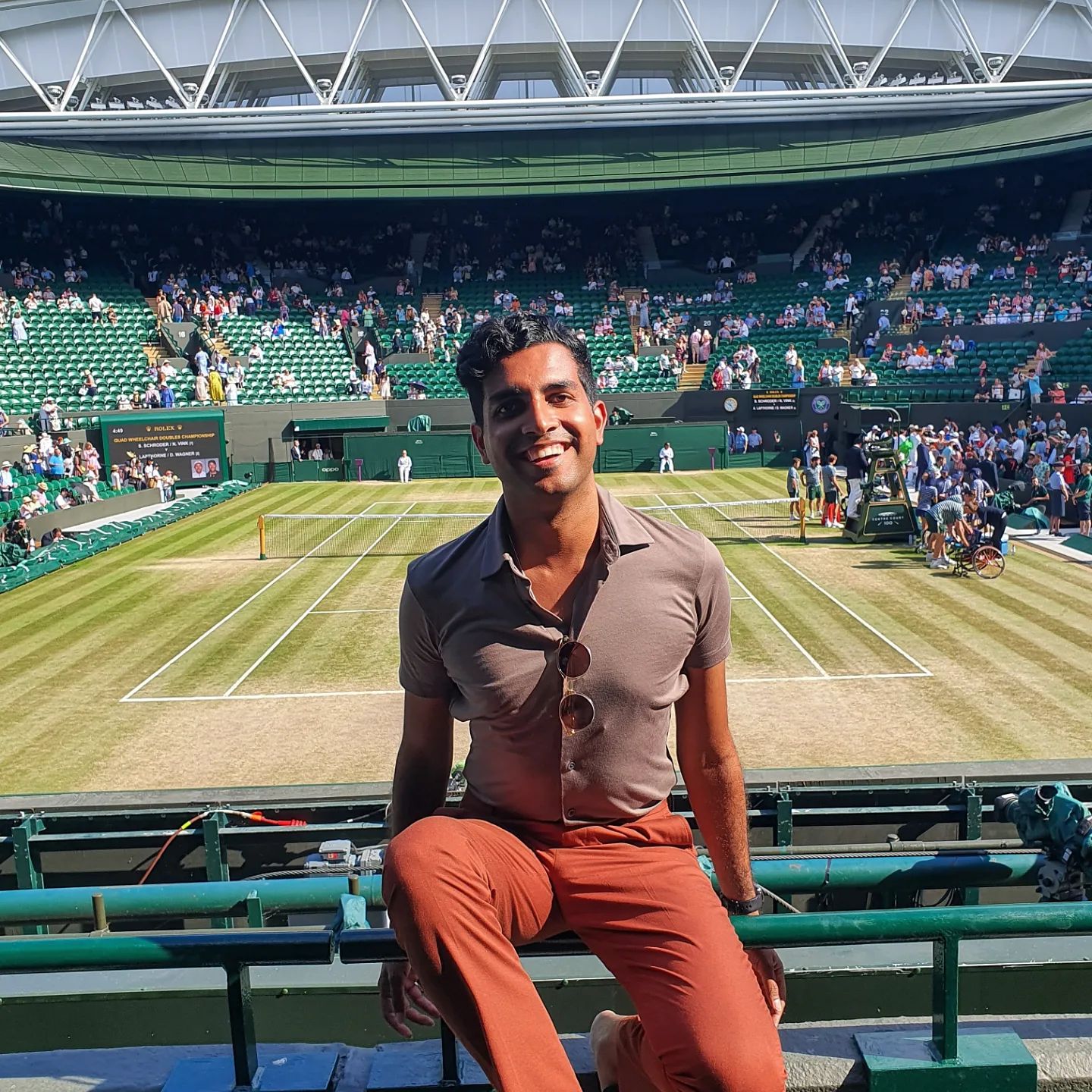 Un homme assis sur un siège dans l'un des courts du tournoi de tennis de Wimbledon