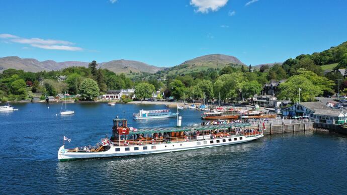 Visitors on a boat cruise on a lake with hills in the background