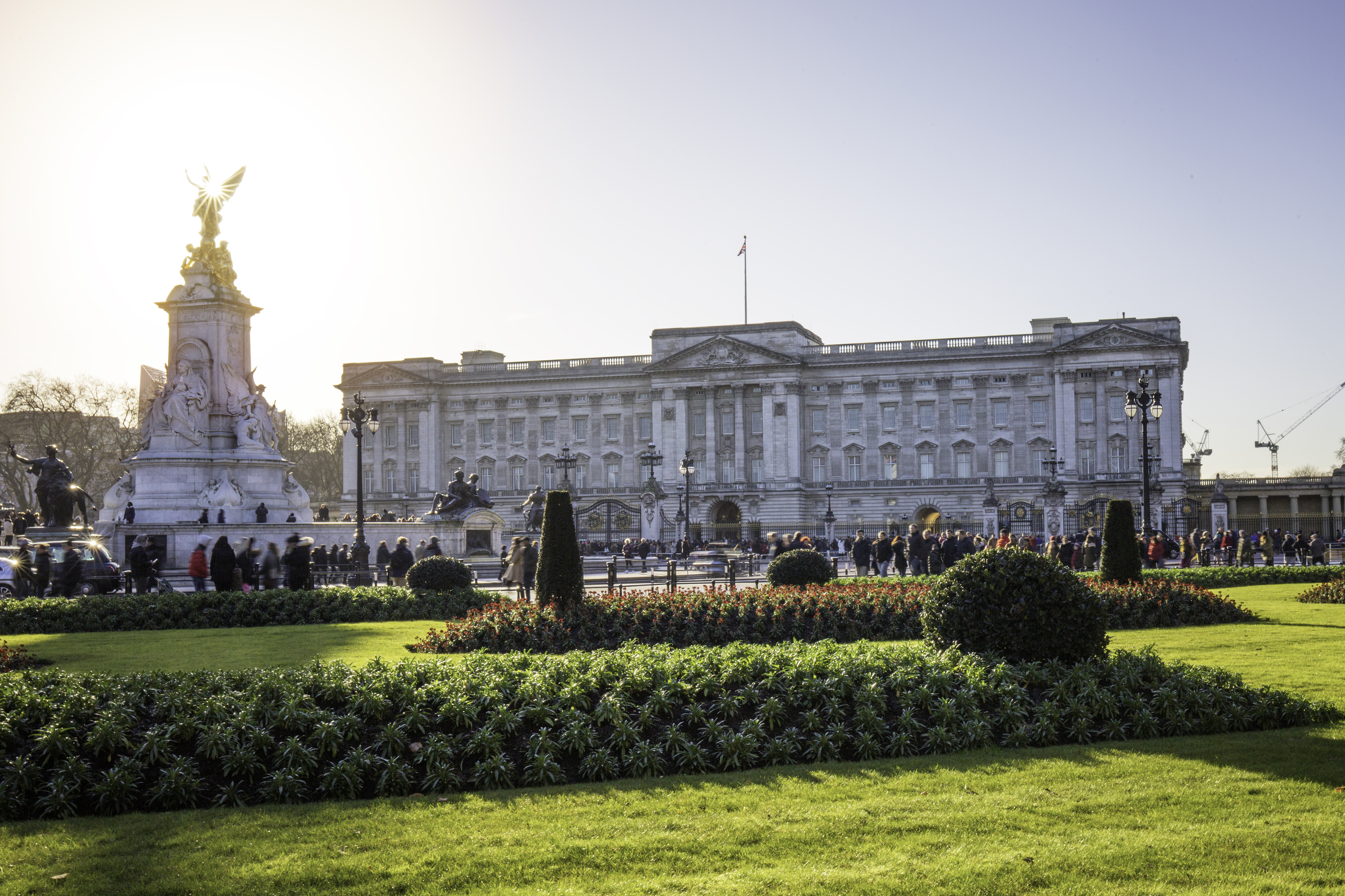 View of Buckingham with gardens in the foreground and people walking by