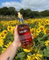 Estate - Una persona con una bottiglia di rum alla Quince Honey Farm