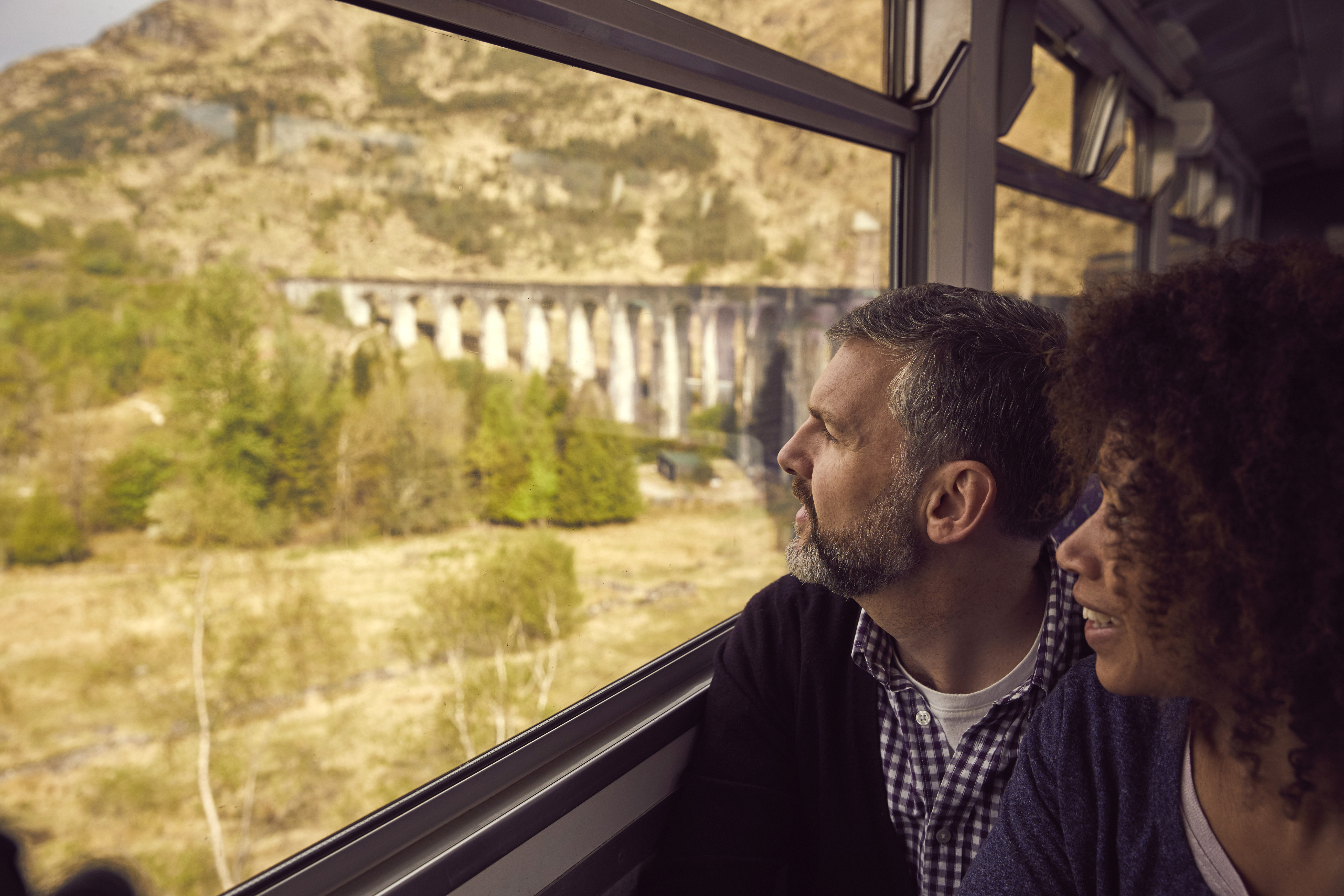 Ein Paar in einem Zug, das aus dem Fenster auf die Landschaft schaut