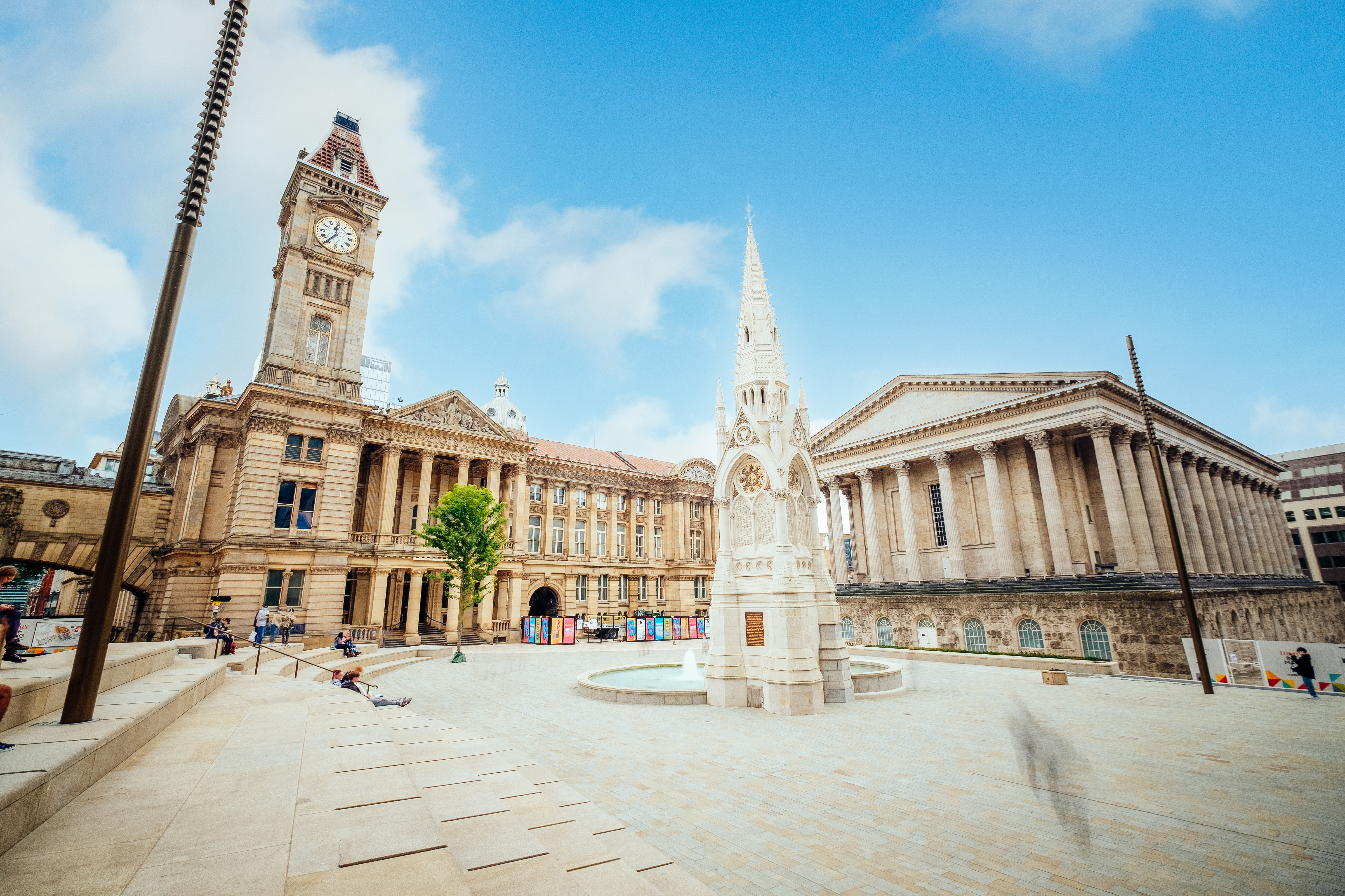 Historical building, with a clock tower, beside a fountain
