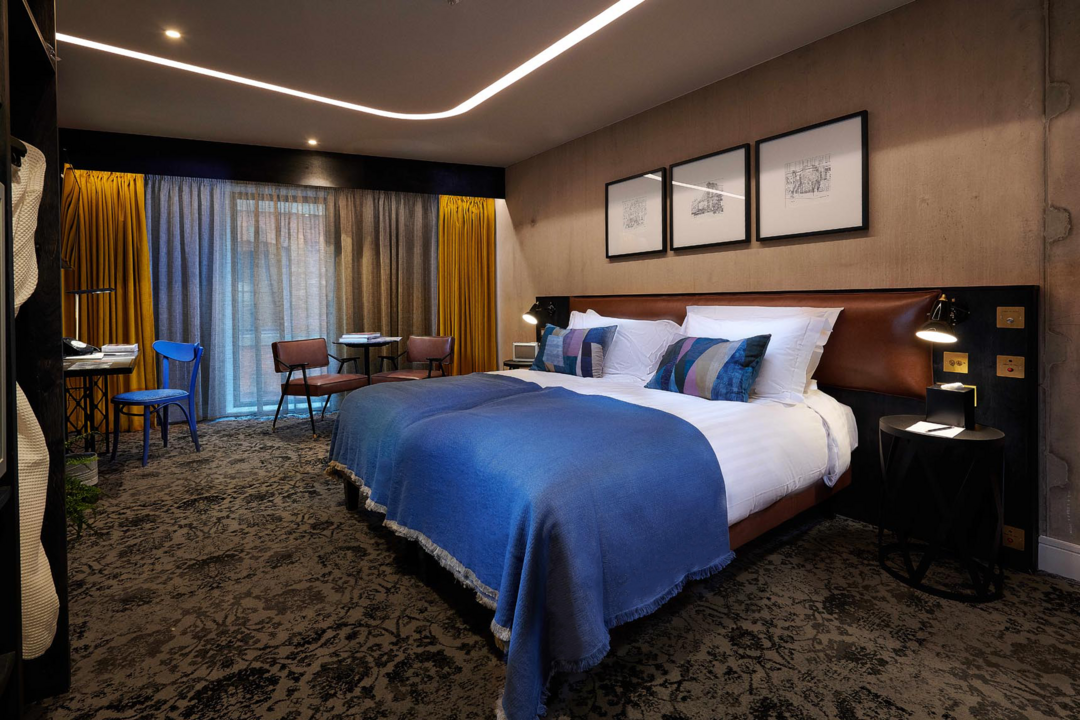 Hotel room interior with double bed and chairs