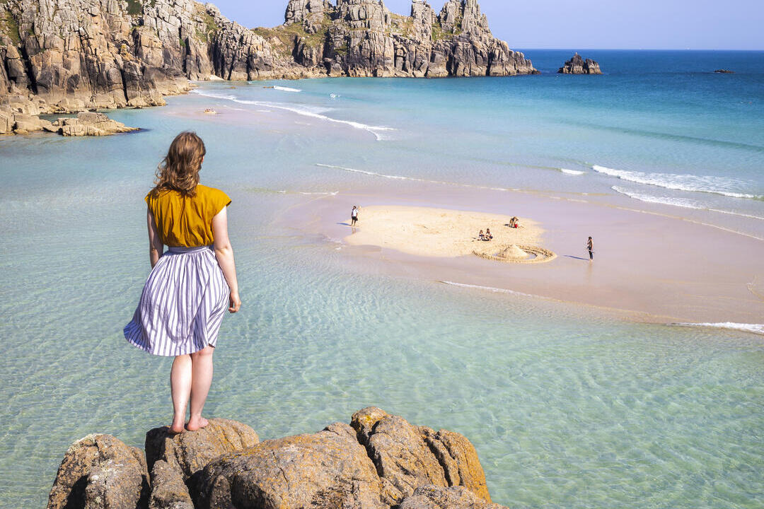 Woman standing on a rock looking out to sea