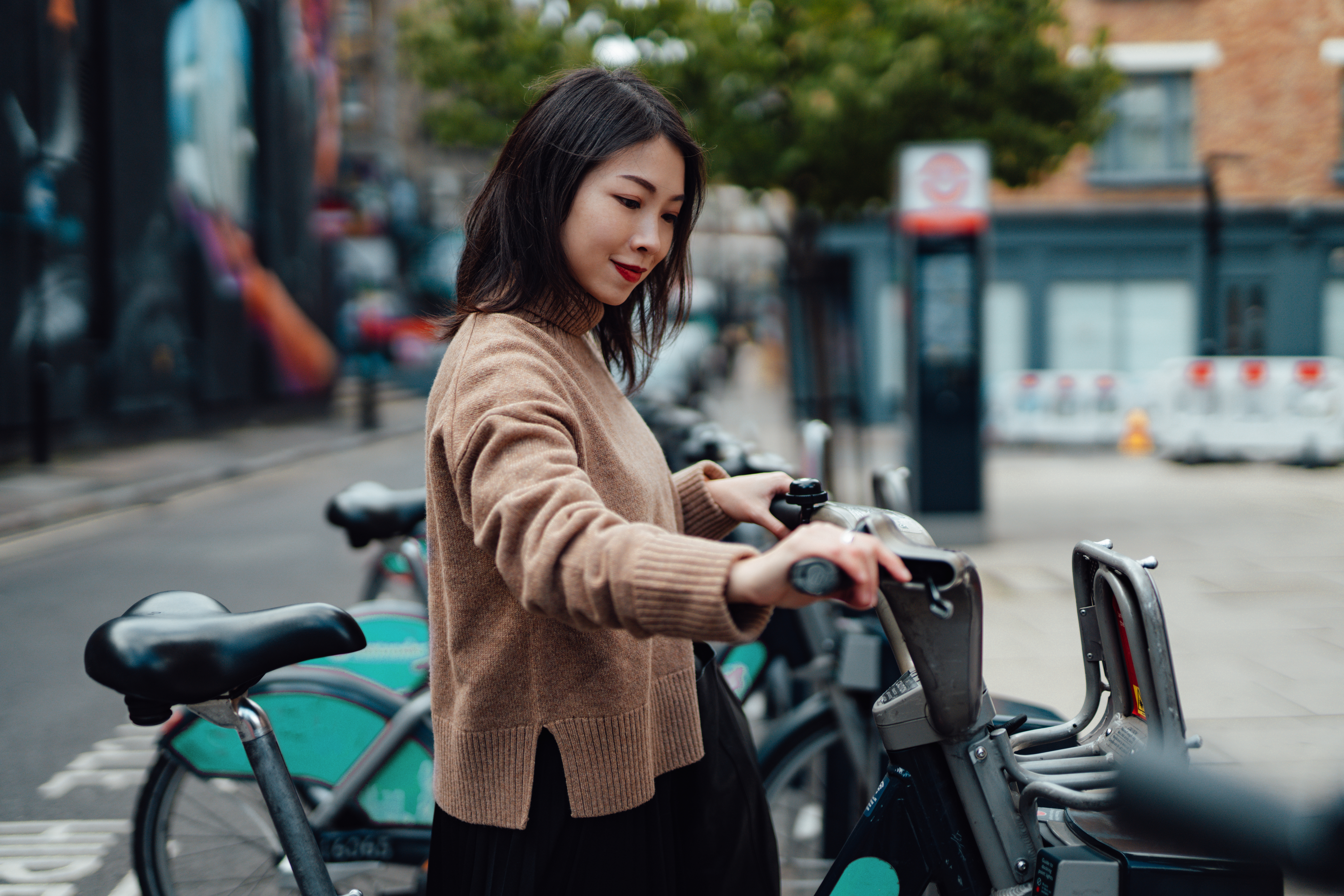 Junge asiatische Frau, die ein Fahrrad bei einem Fahrradverleih mietet