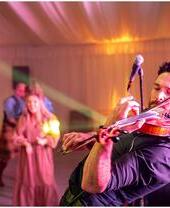 A performer on stage with a violin at the Spirit of Speyside Whiskey Festival
