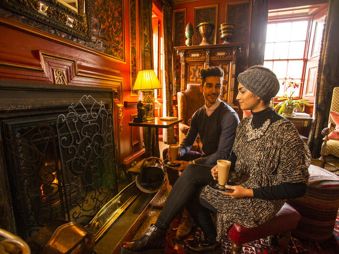 A young Arab couple relaxing by a fire in the drawing room