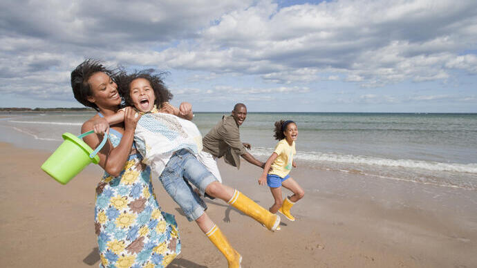 Family playing on the beach in the sunshine