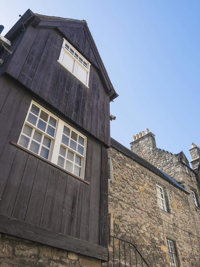 Exterior view of a narrow old street or courtyard with traditional stone and wood buildings.