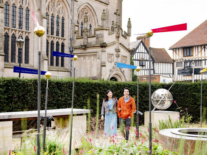 Uomo e donna che camminano in un giardino vicino a una chiesa