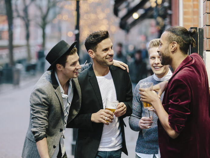 Gay couples standing together and having drinks