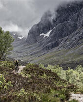 Two mountain bikers cycling on a trail going up a mountain