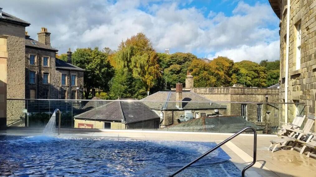 Blick auf das Thermalbad im Freien mit Gebäuden im Hintergrund