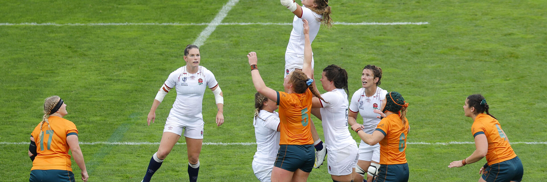 Frauen-Rugbyspiel mit Spielerinnen beider Teams, die auf dem Feld springen, um den Ball zu fangen