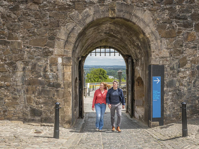A couple exploring the grounds of a medieval castle.