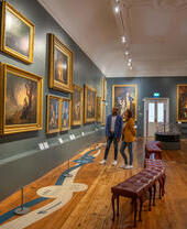 Ein Mann und eine Frau betrachten Gemälde in einer Galerie