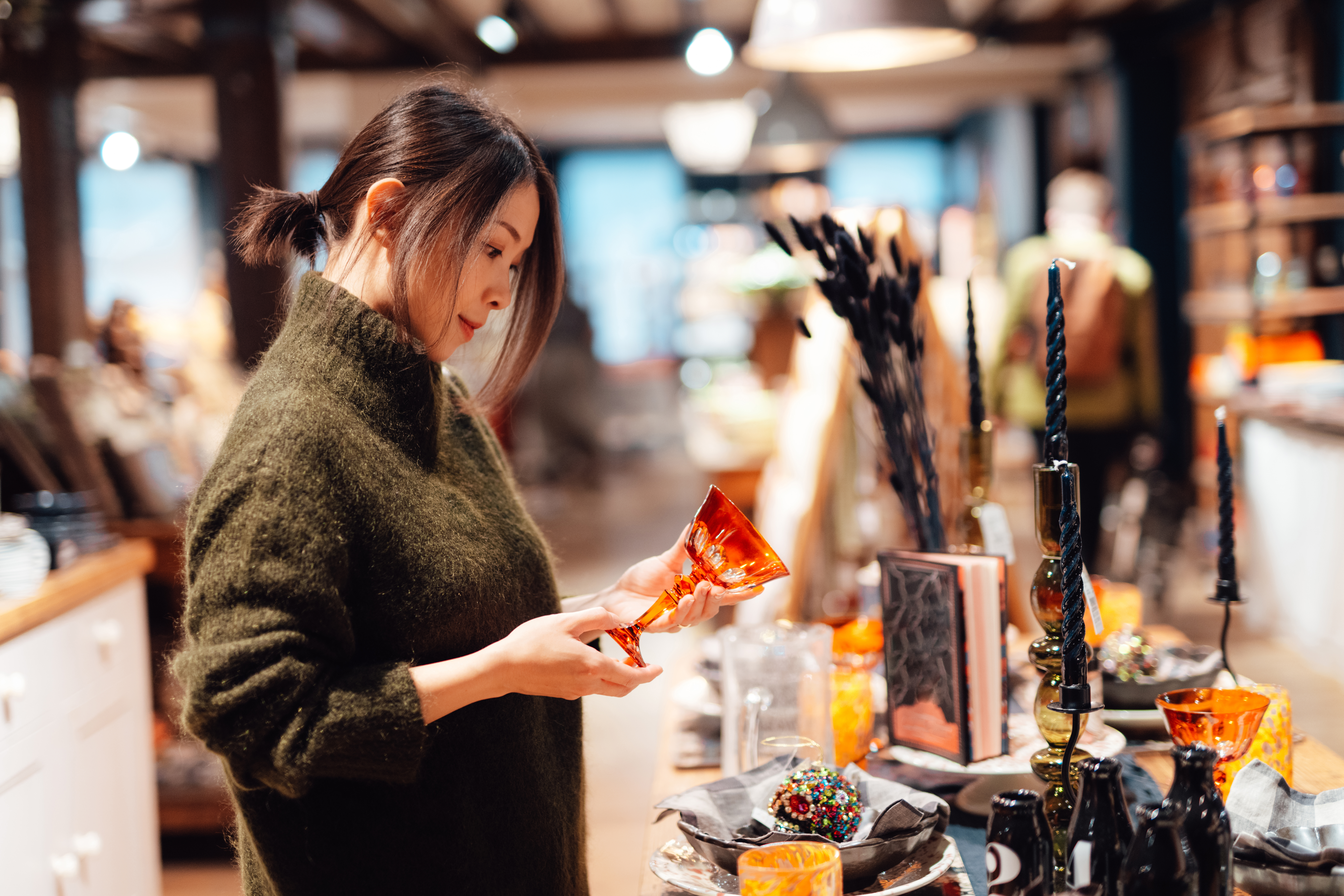 Young Asian woman holding a glass in a department store