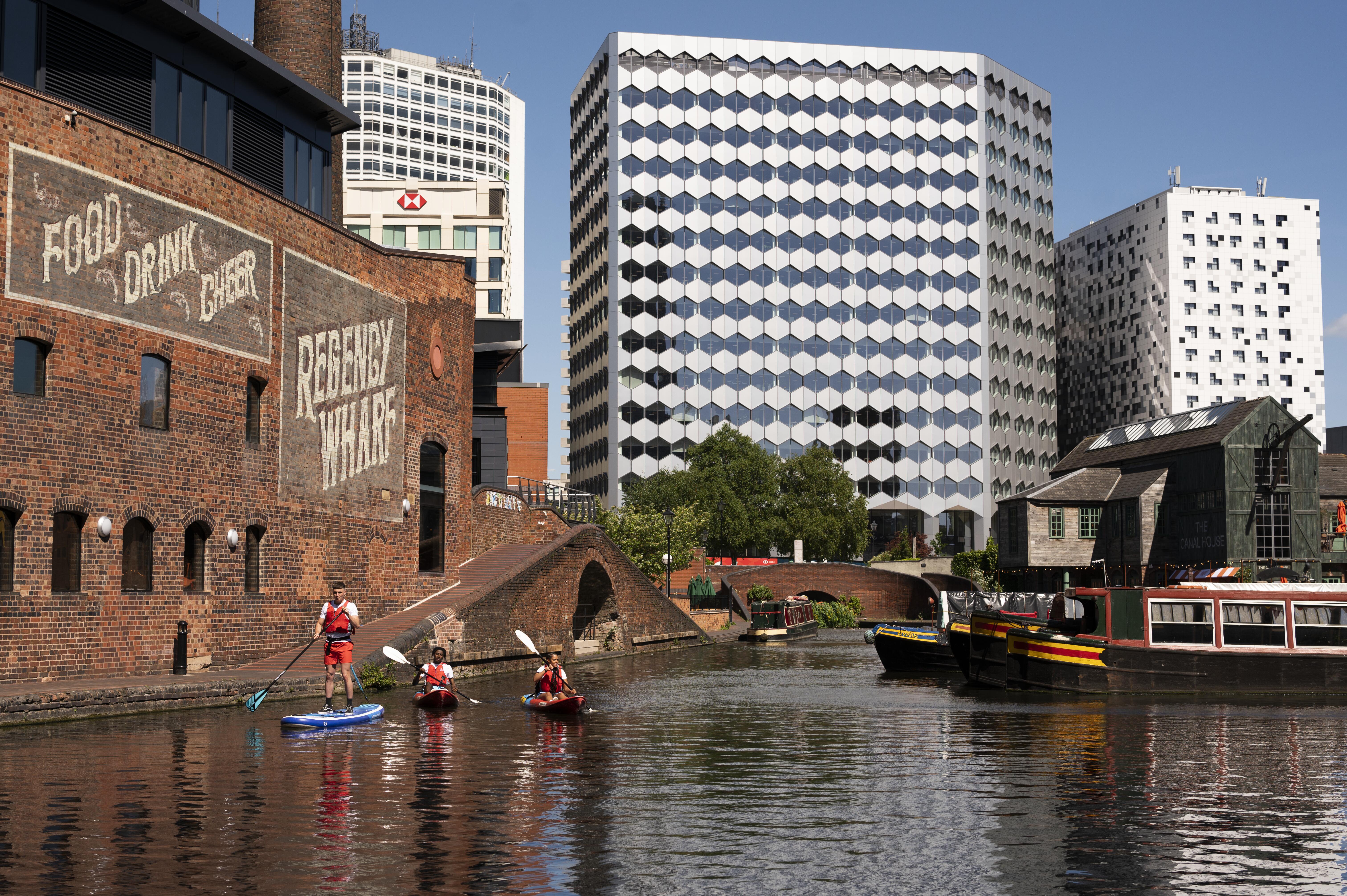 A group of people paddleboarding past the Regency Wharf
