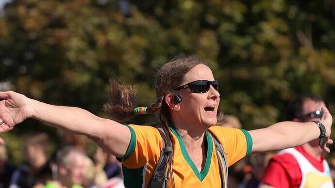 A woman celebrating while crossing the finish line on a run in Newcastle