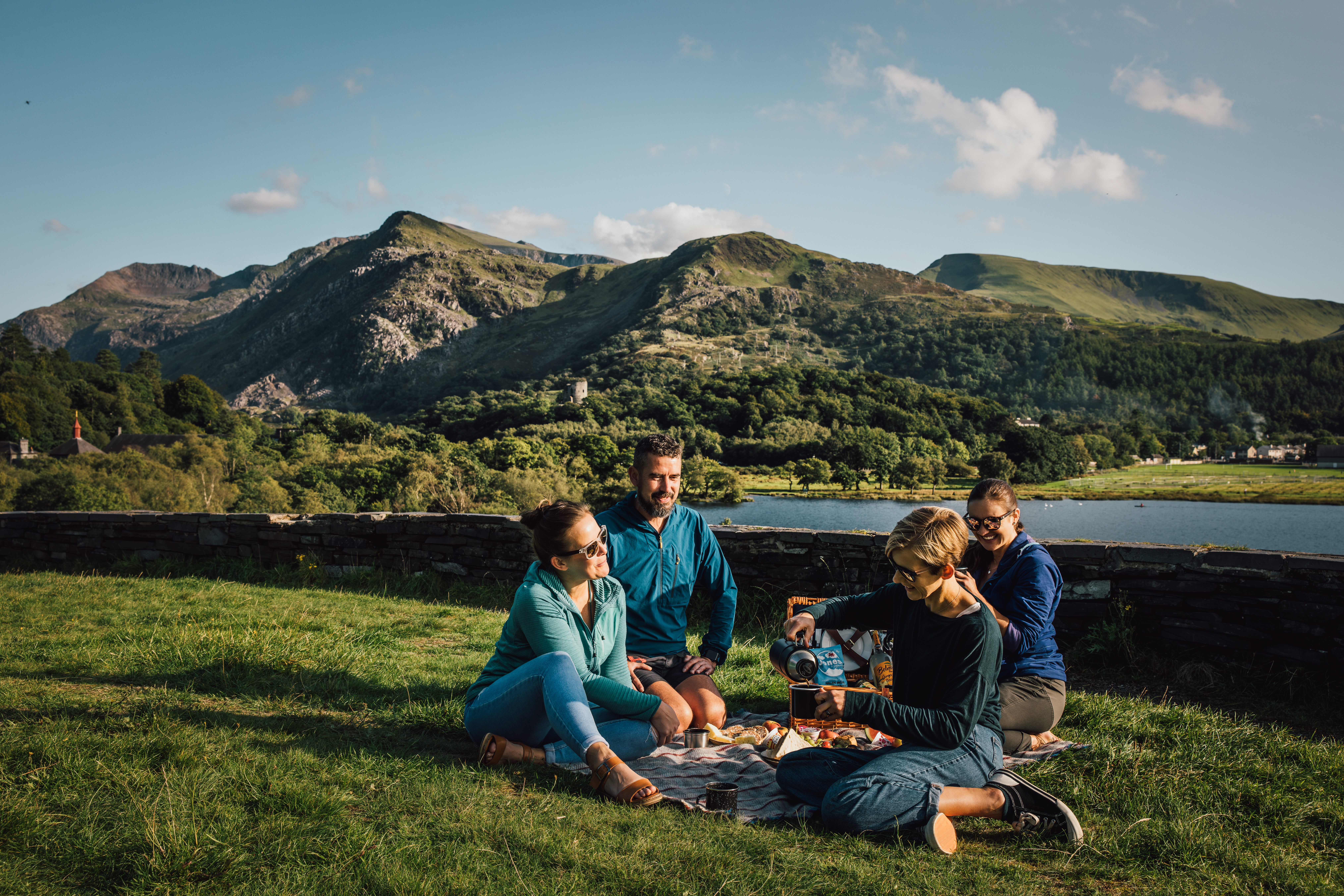 Friends having a picnic in grassland by a glacially formed lake.