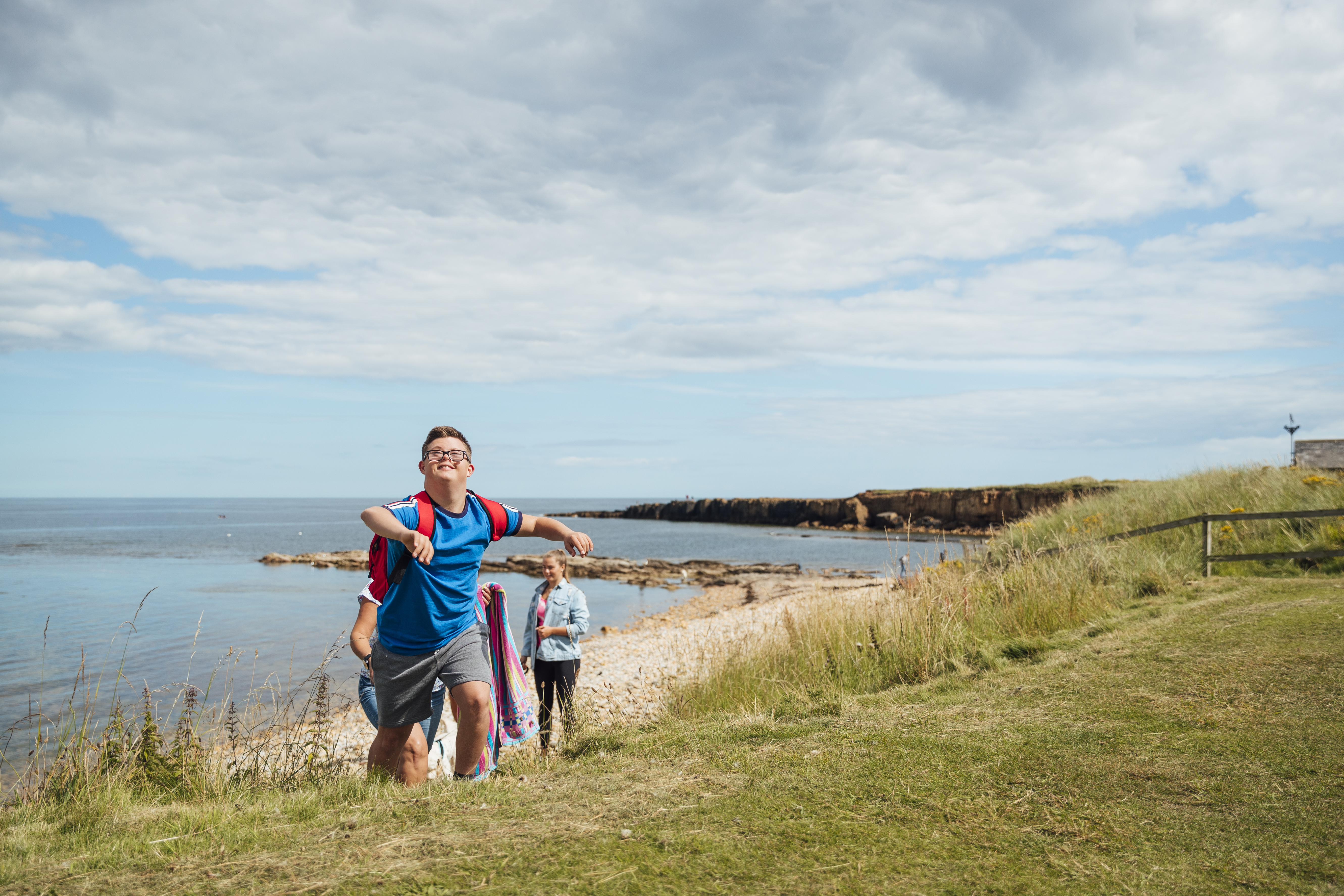 A young boy with Down's Syndrome leaving the beach with his family