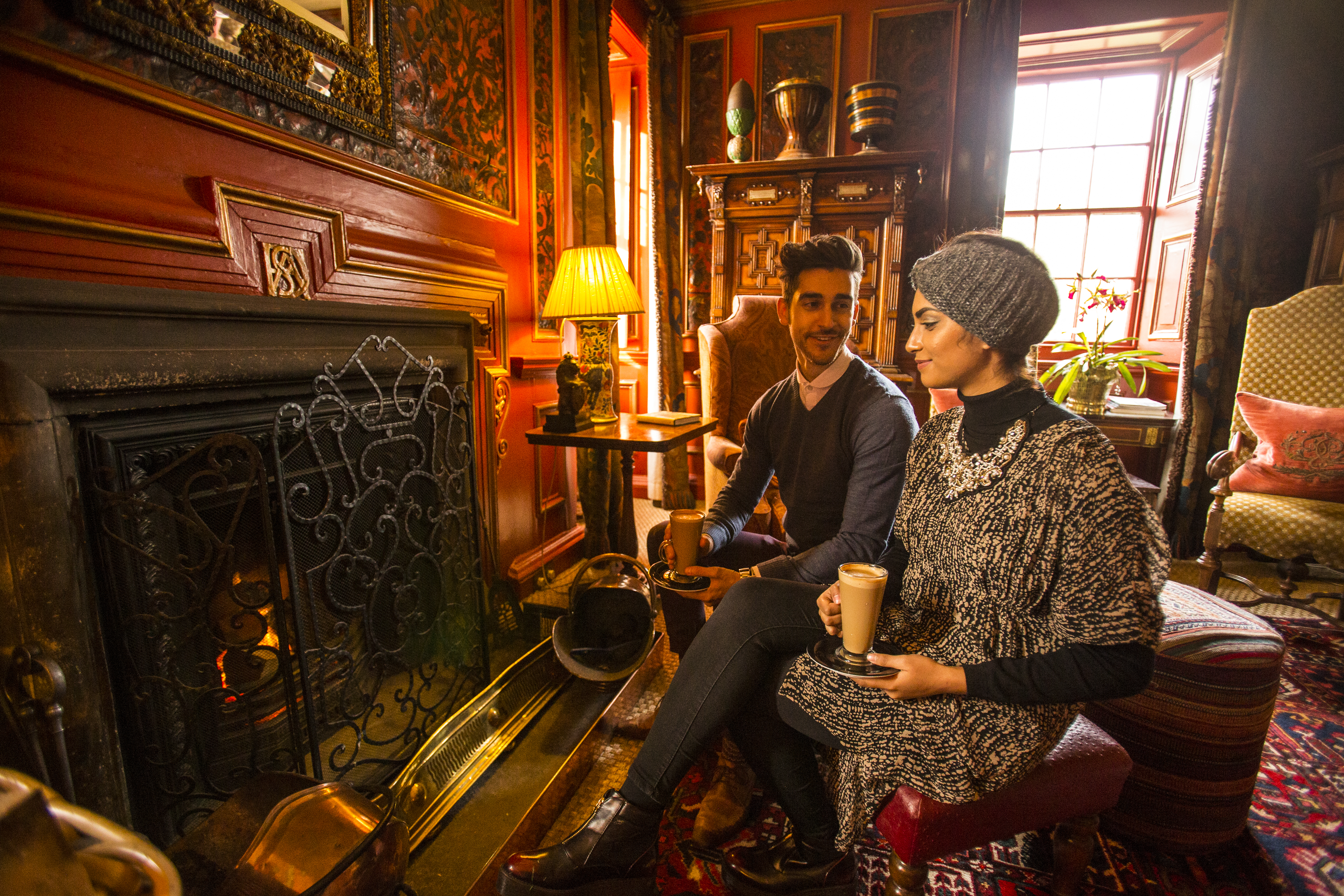 A young Arab couple relaxing by a fire in the drawing room