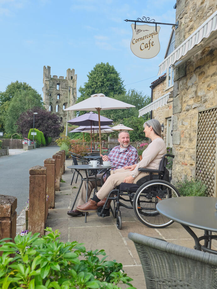 Female wheelchair user and man sitting at a cafe