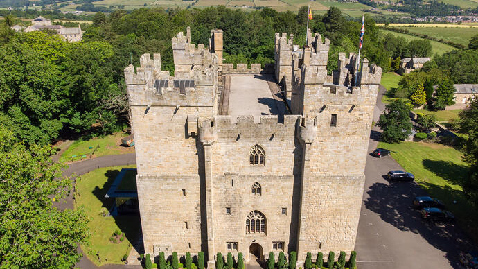 Fourteenth-century castle surrounded by trees and with fields in the distance