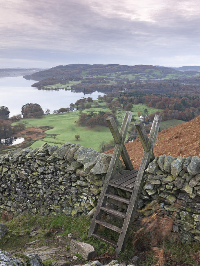 Stile over a drystone wall overlooking landscape of valleys