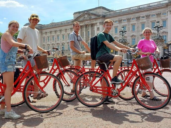 Group of people on bicycles on an Old London Tour in front of Buckingham Palace
