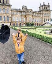 طفلان يلعبان في حديقة قصر كبير.