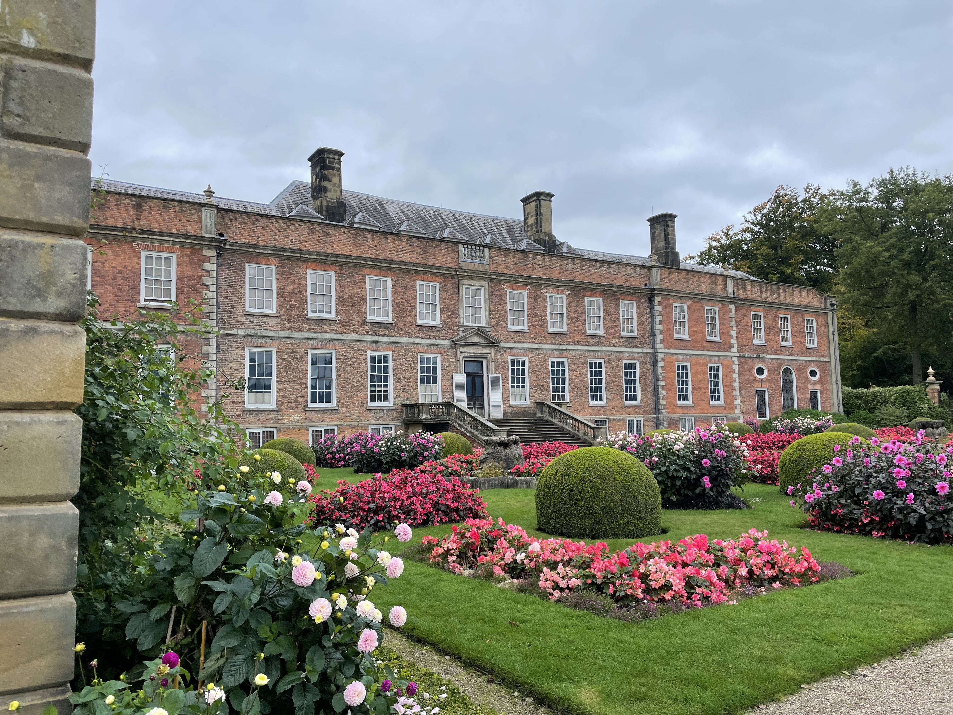 Floral landscaped gardens outside a stately home.