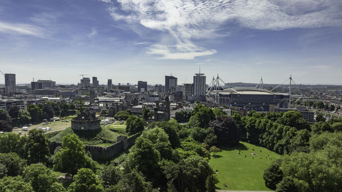 Aerial view of parklands, stadium and buildings of a city.