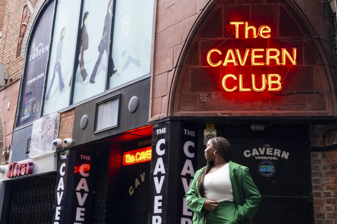 Femme debout dans la rue devant une discothèque