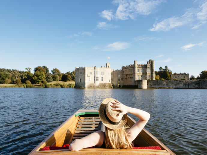 Woman in a punt on the moat looking towards castle