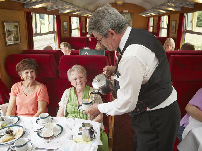 Le personnel de bord sert du café dans le train-restaurant Pullman.