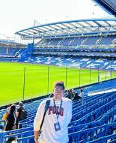 Una persona de pie frente al campo durante una visita al estadio de Stamford Bridge, sede del Chelsea Football Club