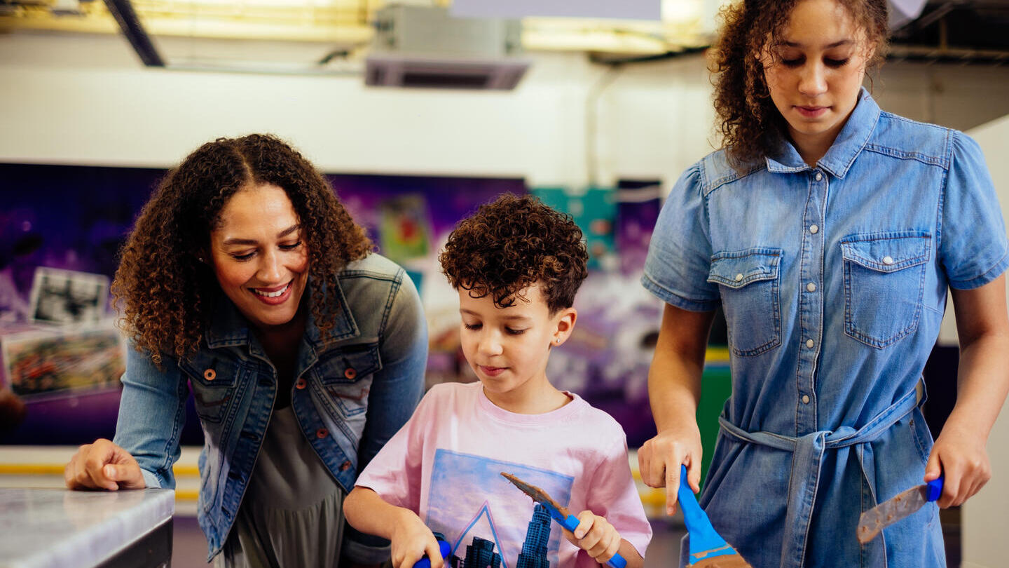 A boy, with curly hair, scraping chocolate off a table